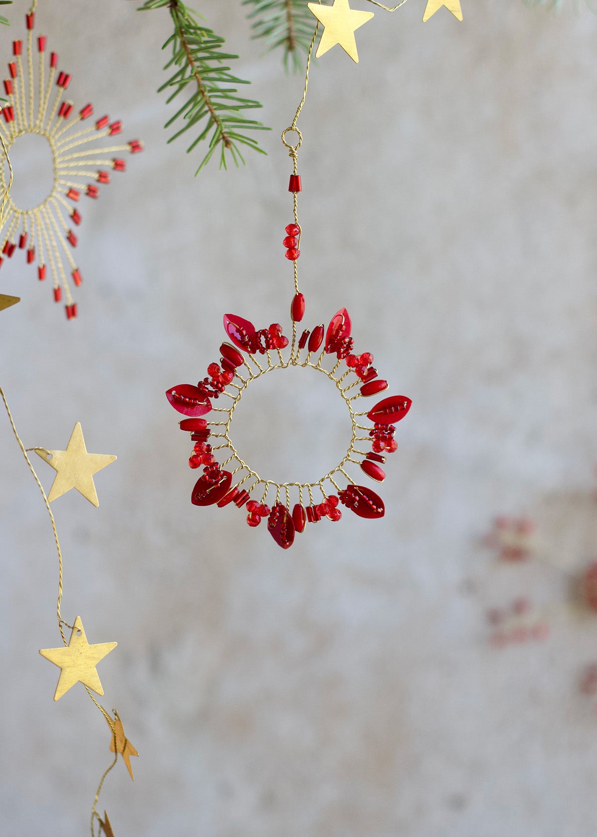 Decorative red and gold circular ornament with stars on a light background