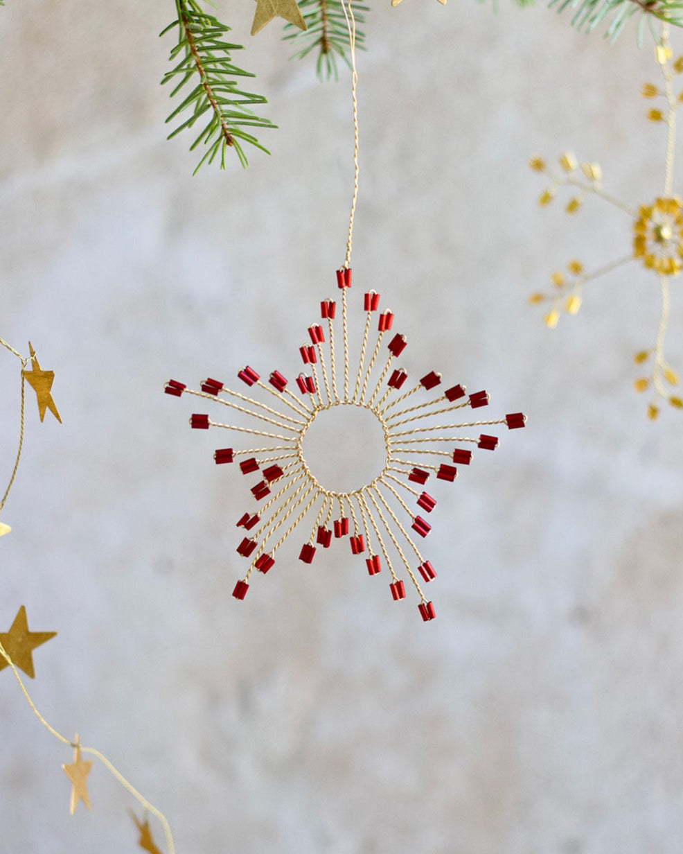 Decorative Christmas ornament with red and gold stars on a neutral background