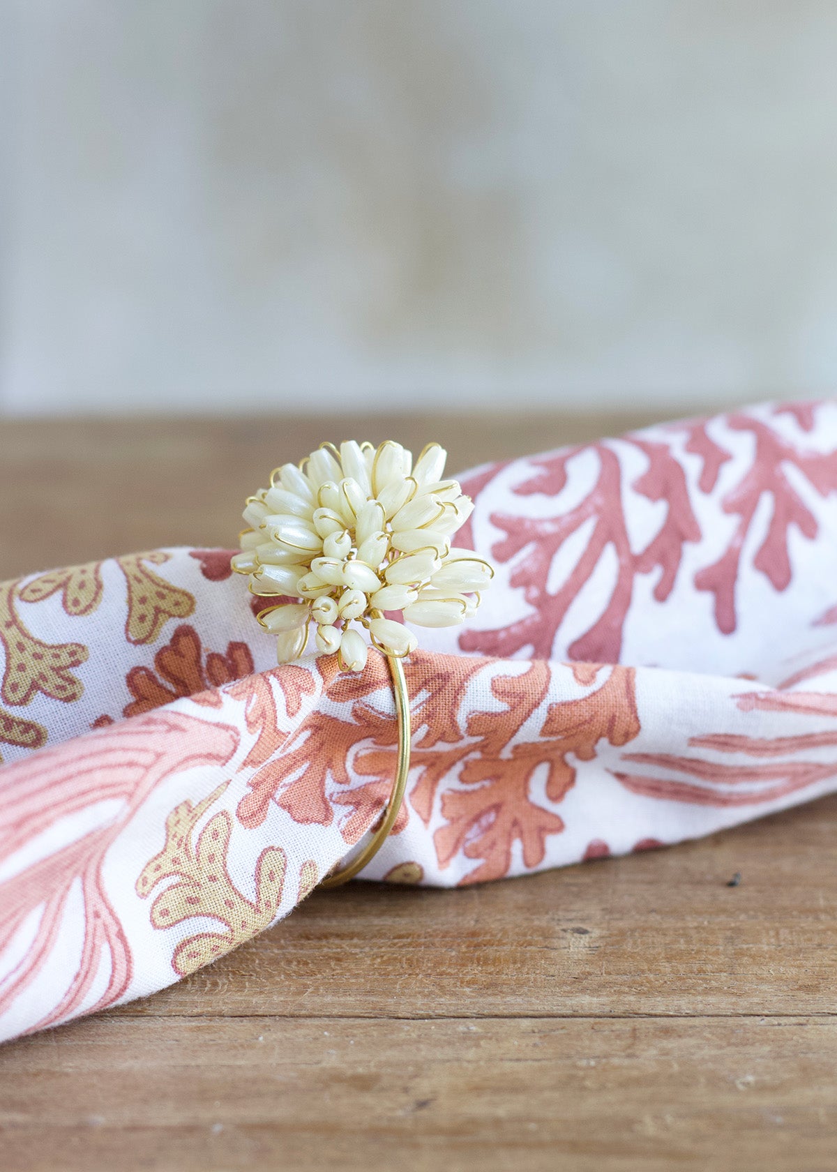 Floral-patterned headband with a decorative flower on a wooden surface