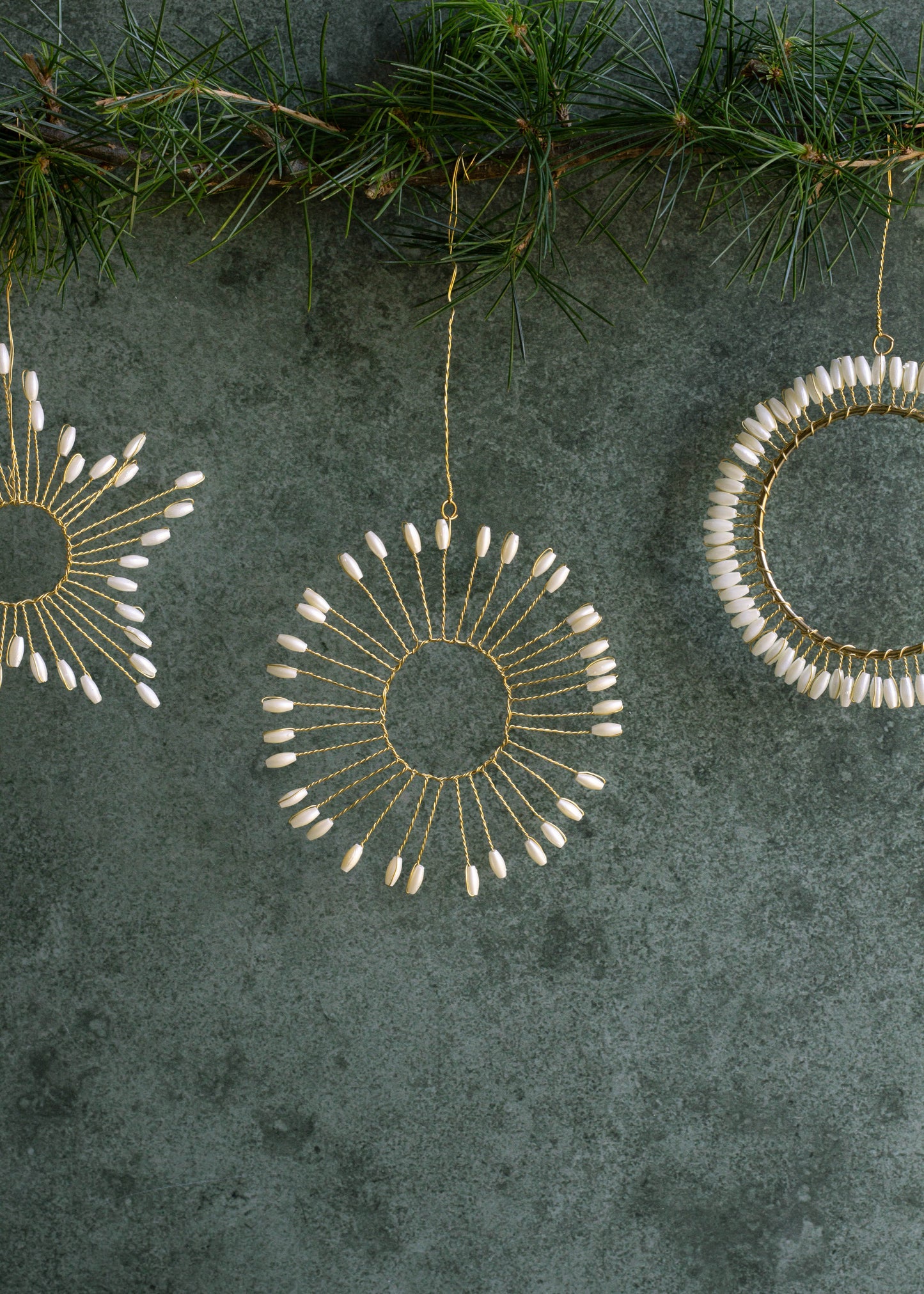 Decorative circular ornaments with bead details on a textured green surface.