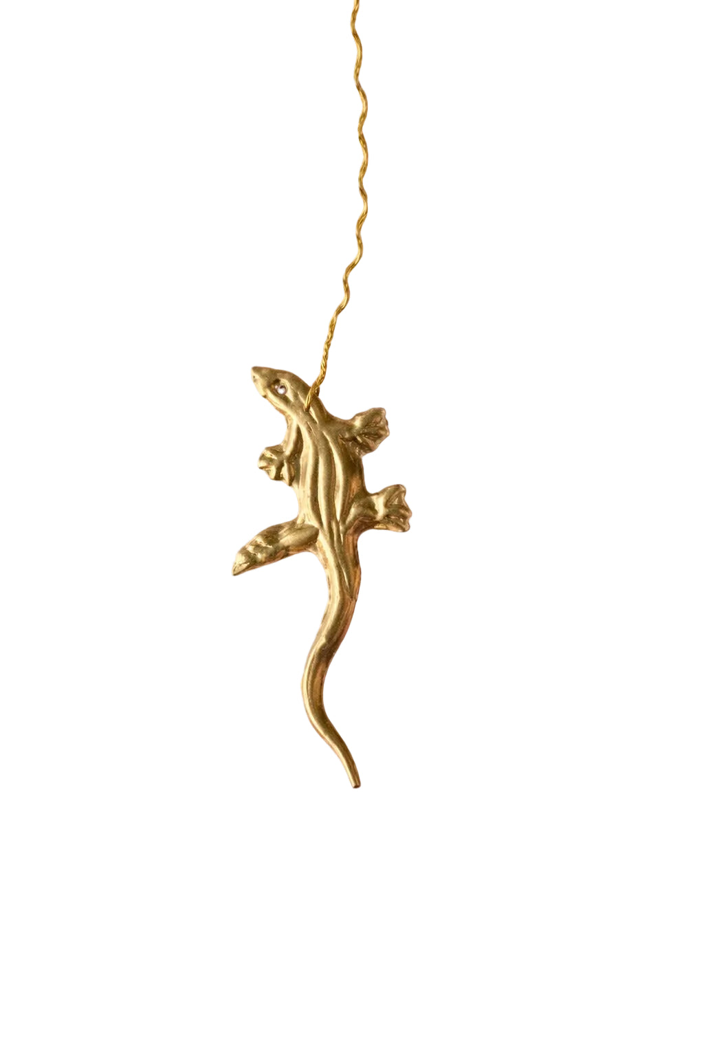 Gold lizard-shaped pendant on a pink background with gold stars.