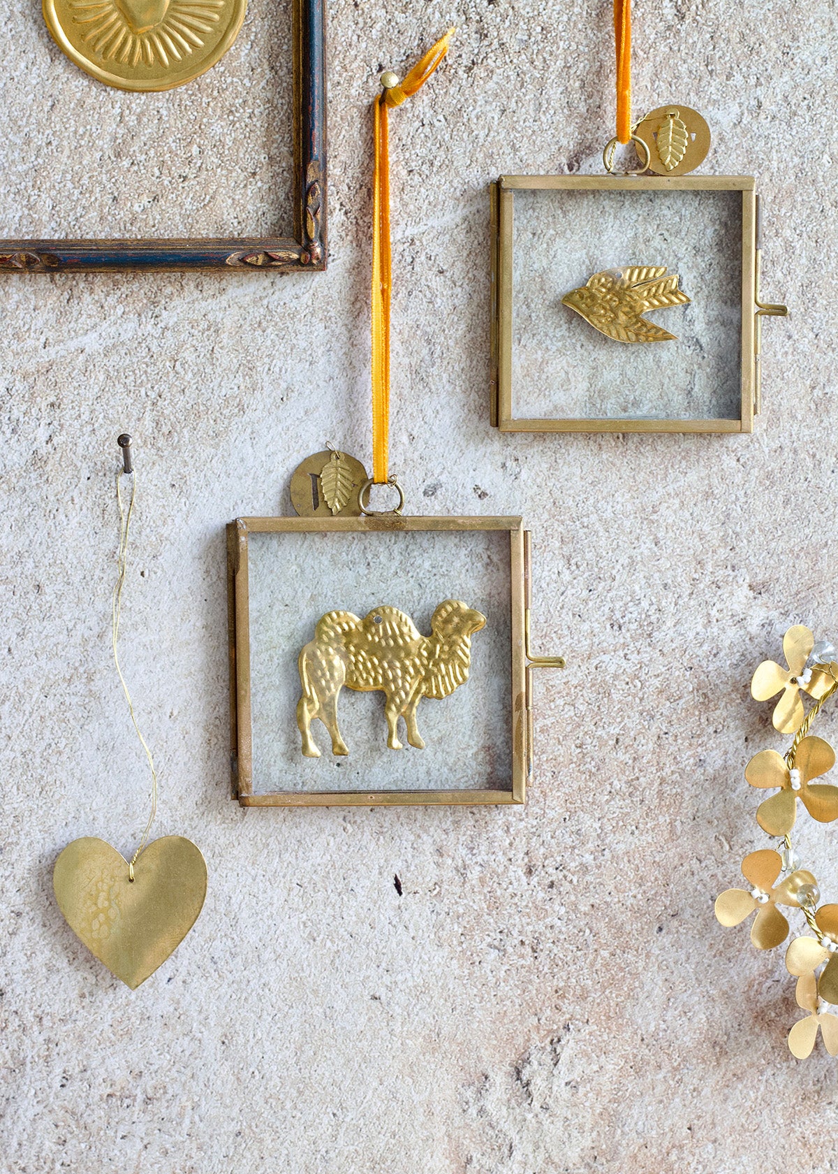 Decorative gold wall art pieces including a camel and heart shapes on a textured wall.