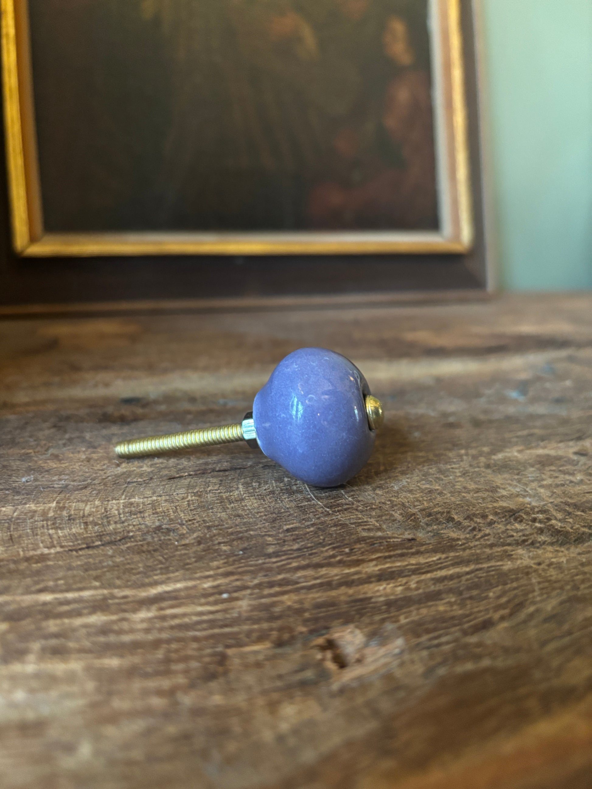 Blue knob on a wooden surface with a blurred background
