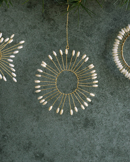 Decorative circular ornaments with bead details on a textured green surface.