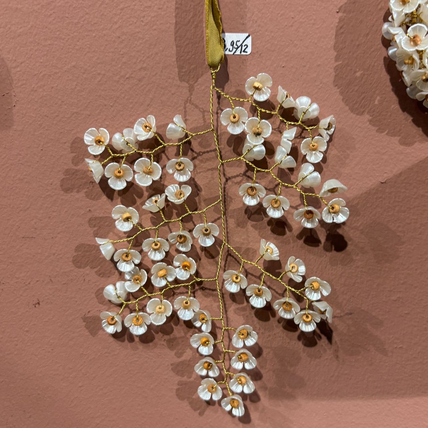Decorative floral branch with white flowers and gold accents on a brown background