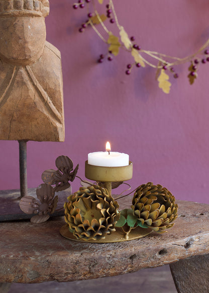 Decorative candle holder with a candle on a rustic surface against a purple wall.